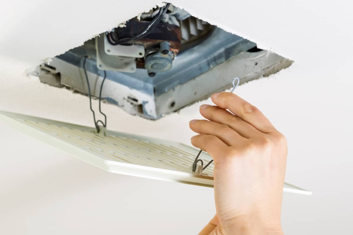 person installing bathroom fan